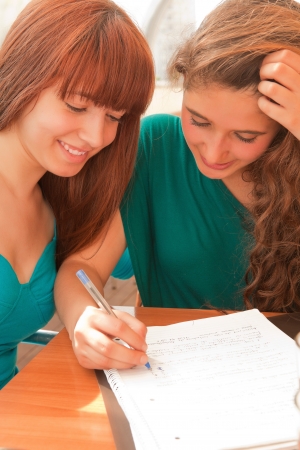 Two happy young beautiful women studying の写真素材