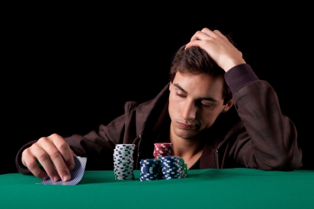 Young handsome man playing texas hold'em pokerの写真素材
