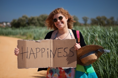 Pretty young woman holding happiness cardの写真素材