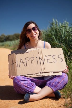 Pretty young woman holding happiness cardの写真素材