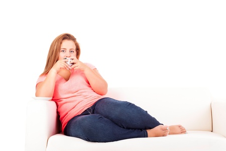 Young overweighted woman relaxing at homeの写真素材