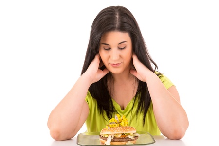Beautiful large woman, trying to resist to an appetizing hamburger, which would kill her dietの写真素材