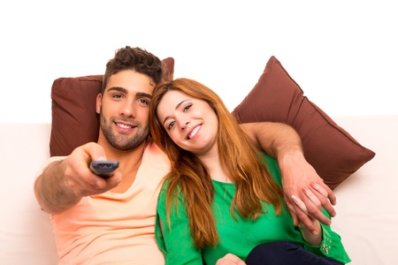 Young couple watching something on the television in the couchの写真素材