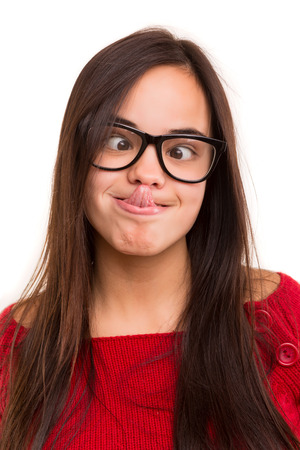 A beautiful young asian woman making a silly expression, isolated over whiteの写真素材