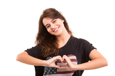 Beautiful woman making a heart shape with her hands, isolated over white の写真素材