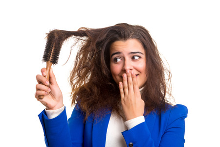Young woman taking care of her hair isolated over whiteの写真素材