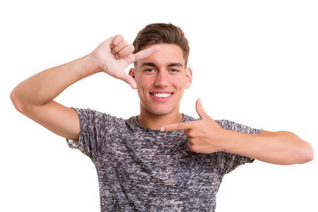 Happy young man framing photography, isolated over whiteの写真素材