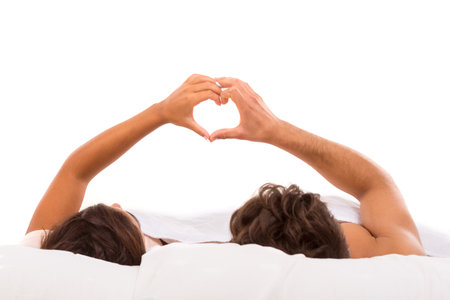 A beautiful young passionate couple in bedの写真素材