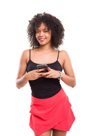 Studio shot: beautiful african woman with a smartphoneの写真素材