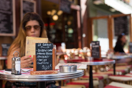 Beautiful young woman at a typical french restaurantの写真素材