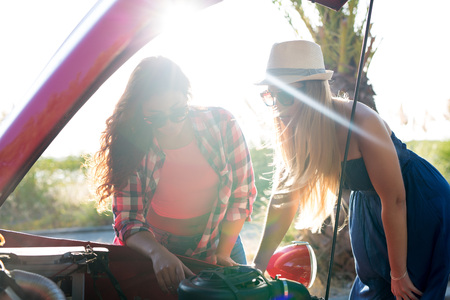Friends on a roadtrip having a problem with their old carの写真素材