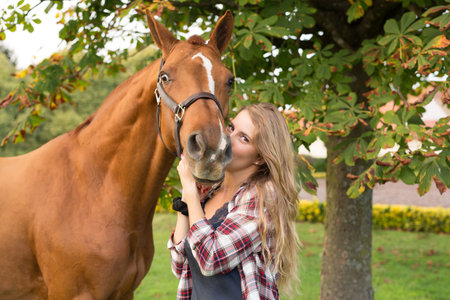 Beautiful and natural young woman spending sometime with her horse