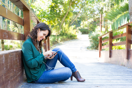 Young woman listening to music at the parkの写真素材