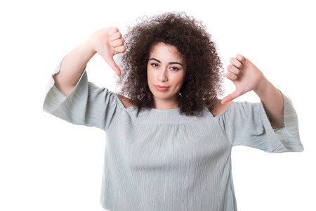 Studio shot of a young woman signaling thumbs downの写真素材