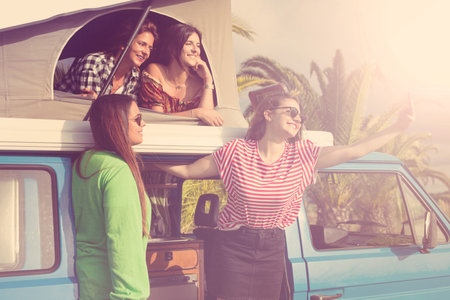 Summer holidays, road trip, vacation, travel and people concept - smiling young hippie women in car