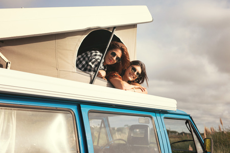 Summer holidays, road trip, vacation, travel and people concept - smiling young hippie women in carの写真素材