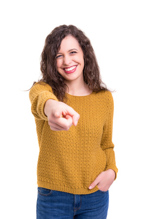 Young beautiful woman pointing at you, isolated over whiteの写真素材
