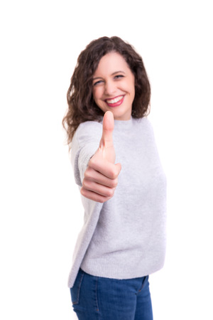 Beautiful young woman signaling ok, isolated over whiteの写真素材