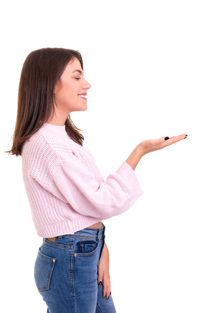 Young beautiful woman presenting your product, isolated over white backgroundの写真素材