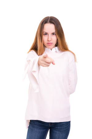 Young beautiful woman pointing at you, isolated over whiteの写真素材