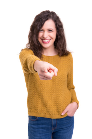 Young beautiful woman pointing at you, isolated over whiteの写真素材