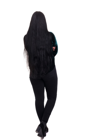 Woman posing with her back faced to camera, isolated over copy space backgroundの写真素材