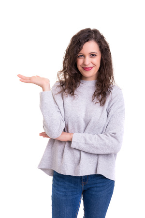 Young beautiful woman presenting your product, isolated over white backgroundの写真素材