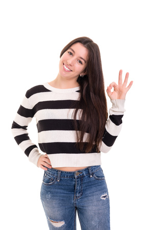 Beautiful young woman signaling ok, isolated over whiteの写真素材
