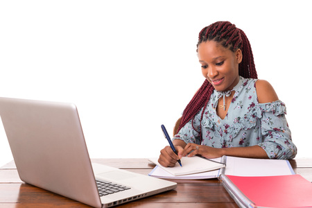 Young african student working with her laptop, isolated over a white backgroundの写真素材