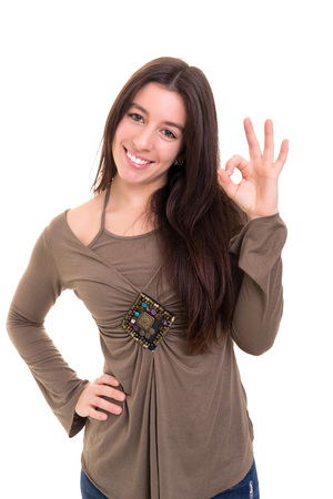 Beautiful young woman signaling ok, isolated over whiteの写真素材