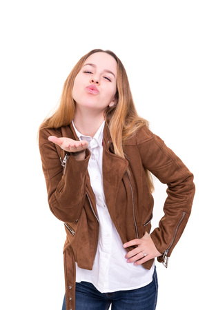 Beautiful young woman blowing you a kiss, isolated over whiteの写真素材
