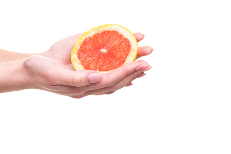 Young woman holding a fresh grapefruit, isolated over white backgroundの写真素材