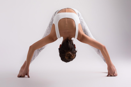 Sporty young woman doing yoga practice isolated on white background - concept of healthy life and natural balance between body and mental developmentの写真素材