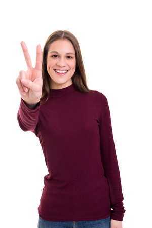 Beautiful young woman signaling victory isolated over whiteの写真素材