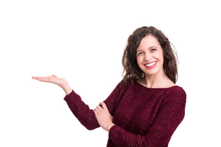 Young beautiful woman presenting your product, isolated over white backgroundの写真素材