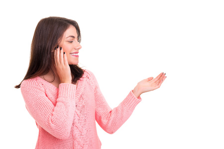 Young beautiful woman presenting your product, isolated over white backgroundの写真素材