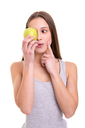 Beautiful blonde woman holding a fresh green apple, isolated over white backgroundの写真素材