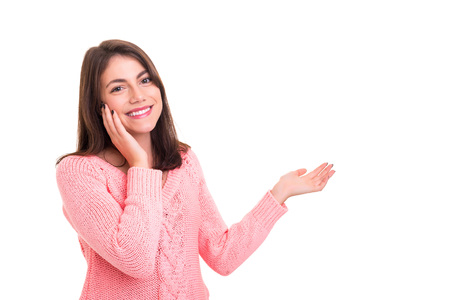 Young beautiful woman presenting your product, isolated over white backgroundの写真素材