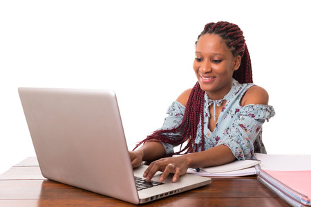 Young african student working with her laptop, isolated over a white backgroundの写真素材
