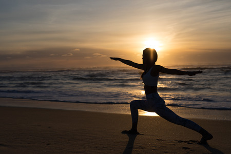 Sporty young woman doing yoga practice at the beach - concept of healthy life and natural balance between body and mental developmentの写真素材