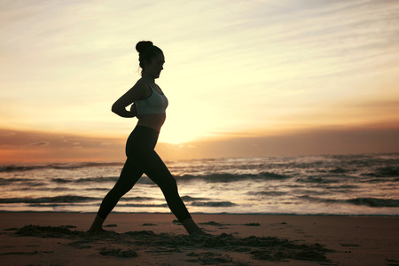 Sporty young woman doing yoga practice at the beach - concept of healthy life and natural balance between body and mental developmentの写真素材