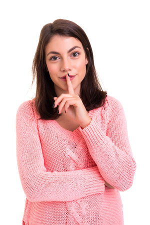 Beautiful young woman asking for silence isolatedの写真素材