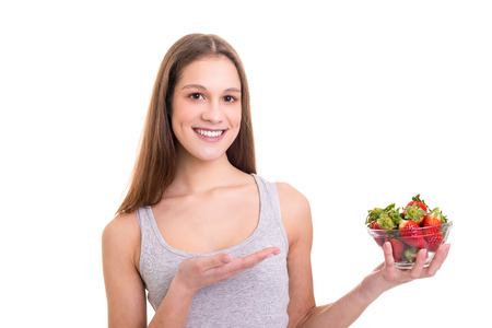 Beautiful young woman holding some strawberries, isolated over white backgroundの写真素材