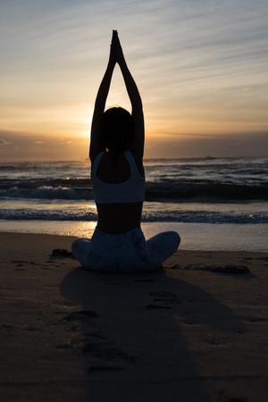 Sporty young woman doing yoga practice at the beach - concept of healthy life and natural balance between body and mental developmentの写真素材