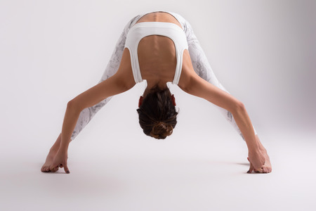 Sporty young woman doing yoga practice isolated on white background - concept of healthy life and natural balance between body and mental developmentの写真素材