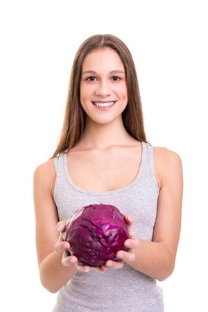 Young woman holding a fresh purple cabbage, isolated over white backgroundの写真素材