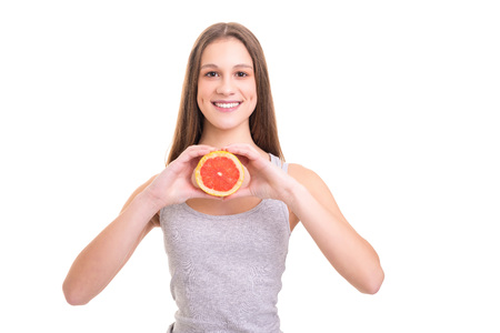 Young woman holding a fresh grapefruit, isolated over white backgroundの写真素材