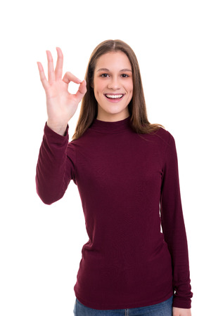Beautiful young woman signaling ok, isolated over whiteの写真素材