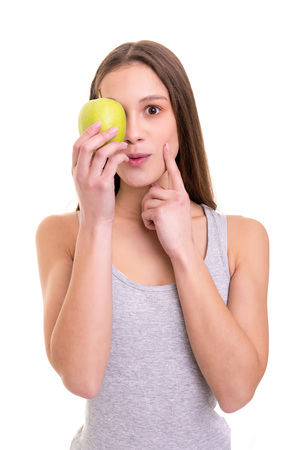 Beautiful blonde woman holding a fresh green apple, isolated over white backgroundの写真素材