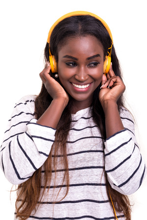 Beautiful young african woman listening to music, isolated over whiteの写真素材